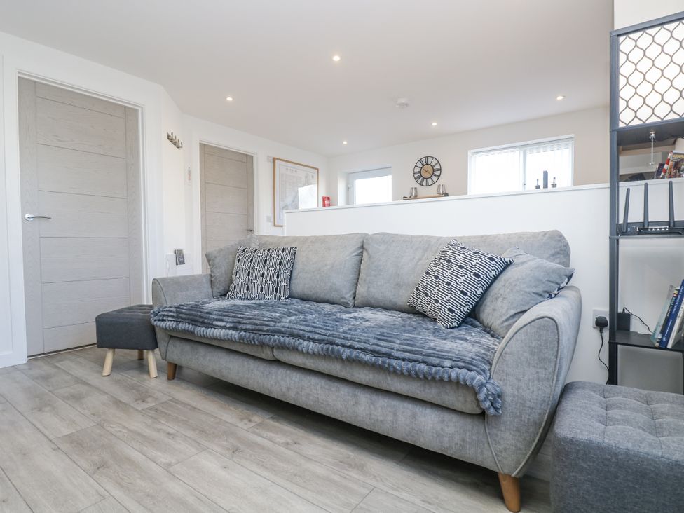 A living room with a sofa and bookshelves at Cosy Retreat in Pool