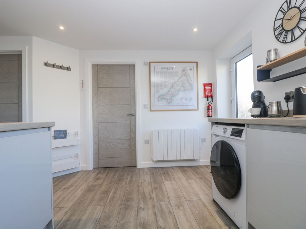 A kitchen with a washing machine and a map at Cosy Retreat Pool