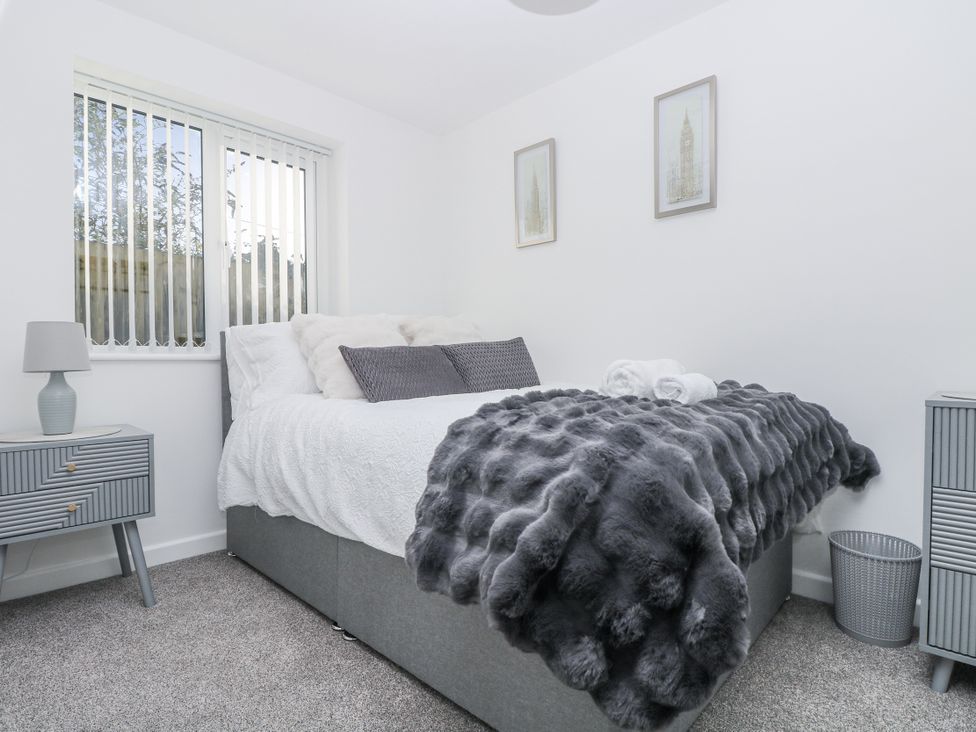 A bedroom with a bed and bedside table at Cosy Retreat in Pool