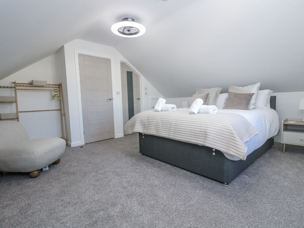A bedroom with a bed and sitting chair at Cosy Retreat in Pool