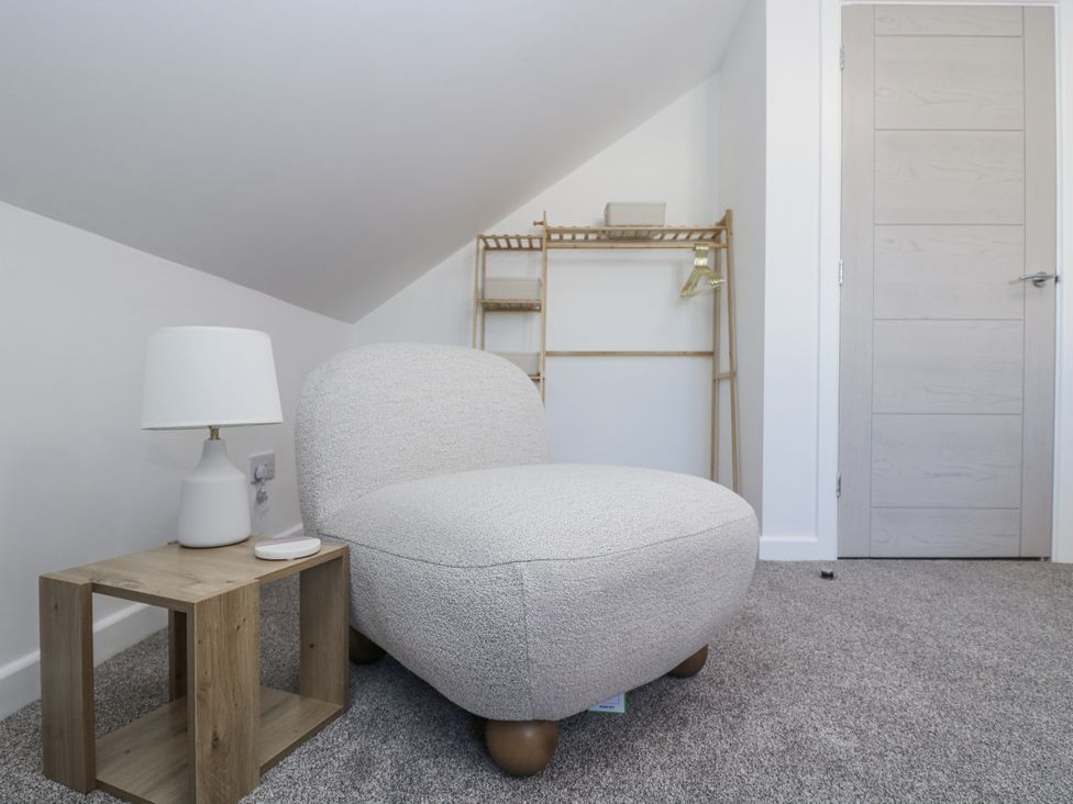 A chair next to a lamp and table at Cosy Retreat in Pool