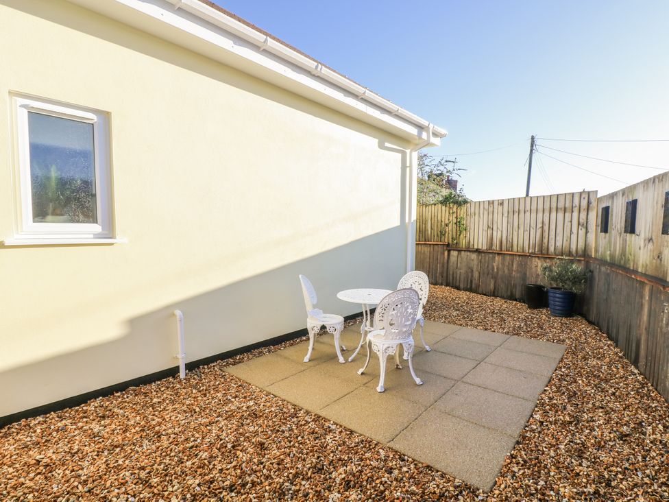 A garden with a table and chairs at Cosy Retreat in Pool