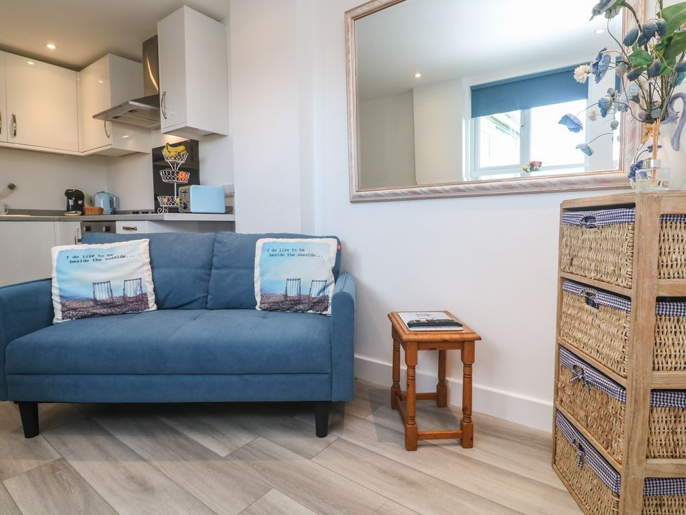 A living room with a couch and a table at Sea Whispers in Marazion