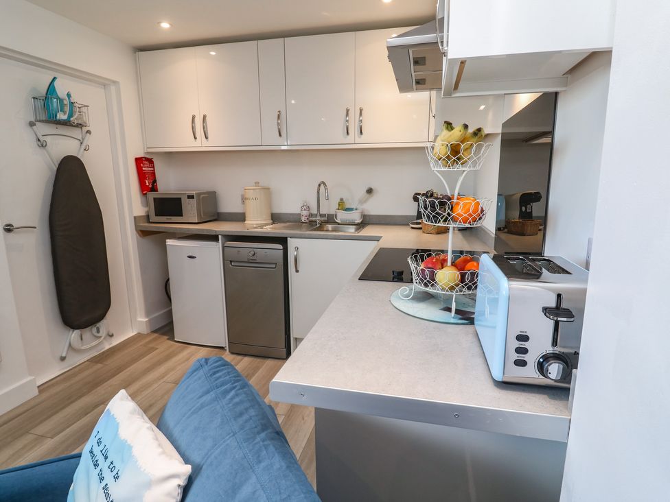 A kitchen featuring a sink, microwave, and refrigerator at Sea Whispers in Marazion
