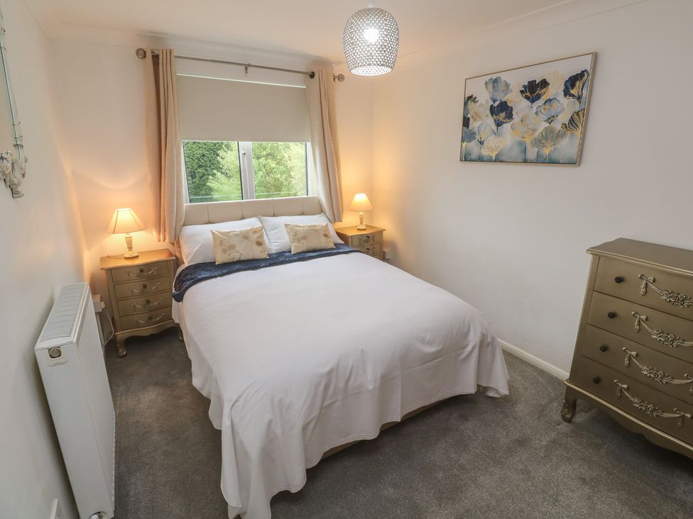 A bedroom with a bed and bedside tables at Sea Whispers in Marazion