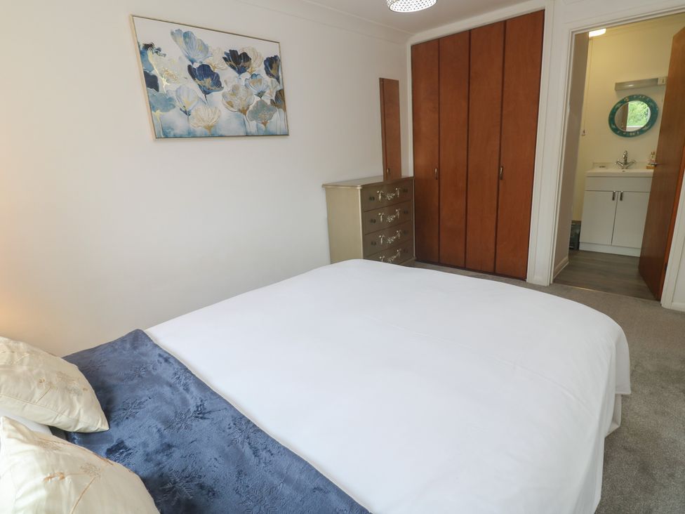 A bedroom with a bed and dresser at Sea Whispers in Marazion