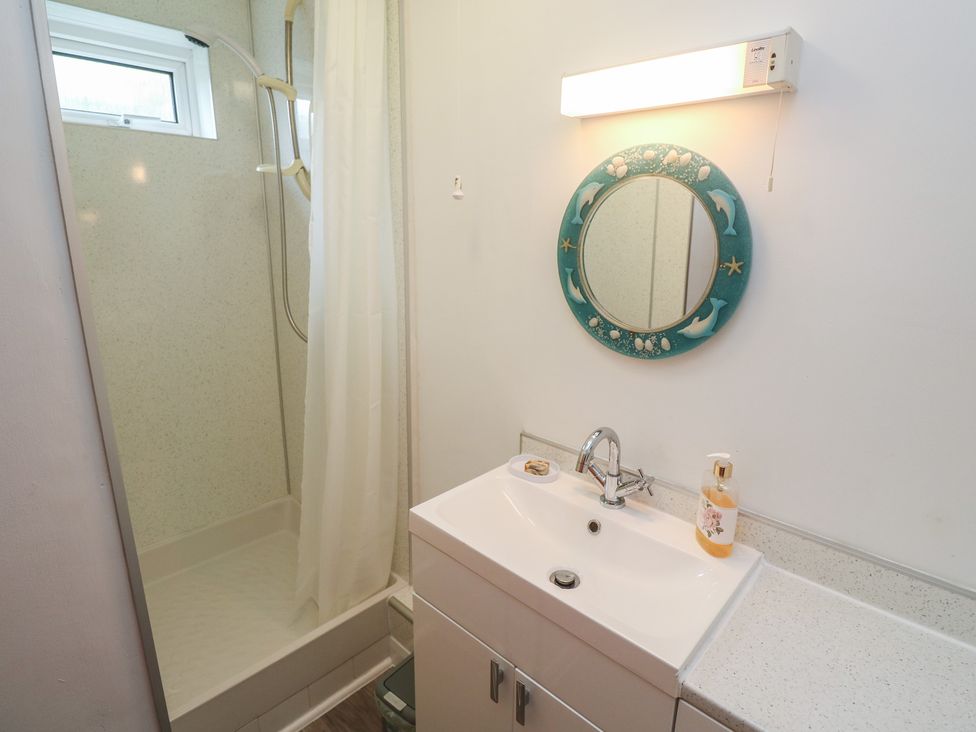 A bathroom with a shower and sink at Sea Whispers in Marazion