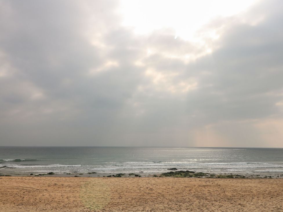 A beach with waves and clouds at Sea Whispers in Marazion