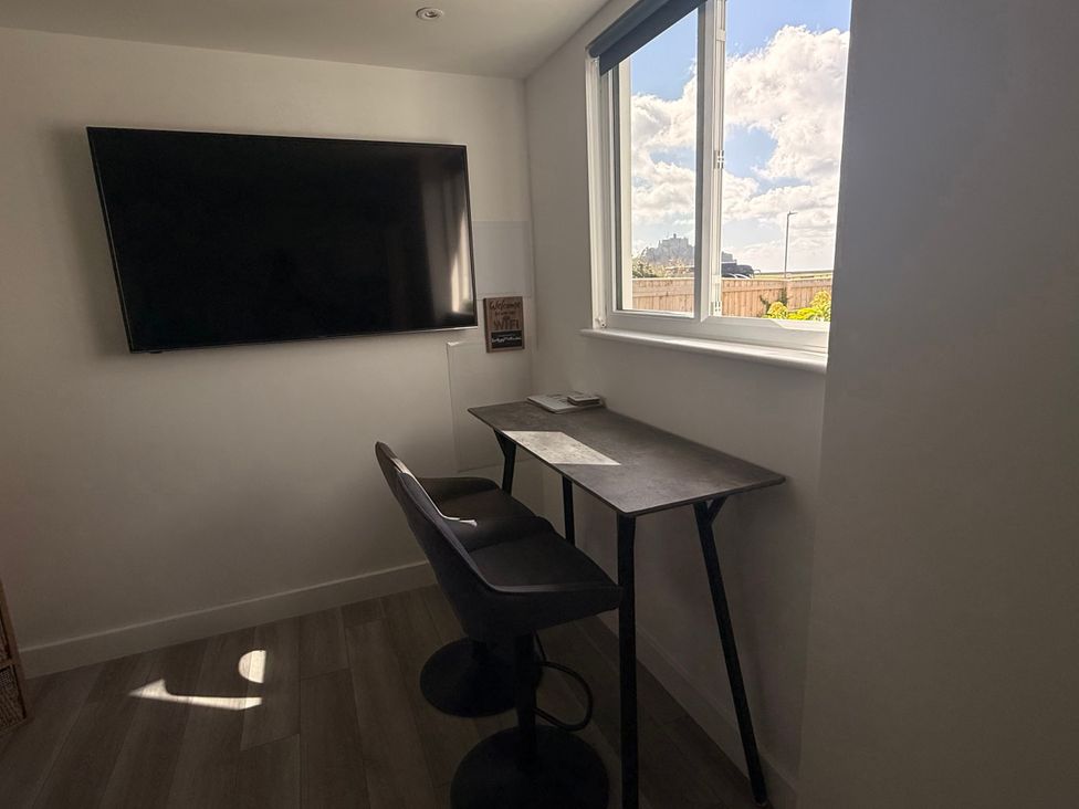 An office with a desk and a television at Sea Whispers in Marazion