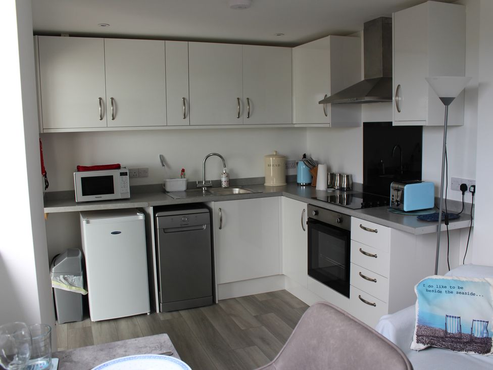 A kitchen with appliances and cabinets at Sea Whispers in Marazion