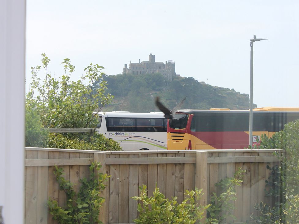 A view of a bus with a building on a hill at Sea Whispers in Marazion