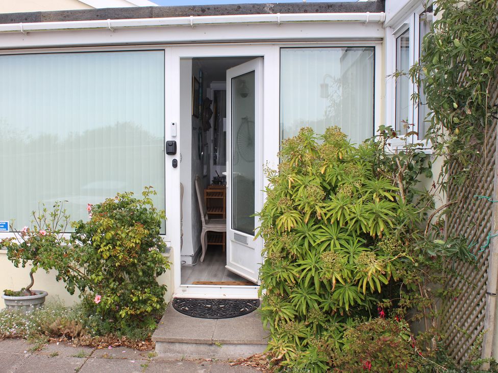 An entrance with a door surrounded by plants at Sea Whispers in Marazion