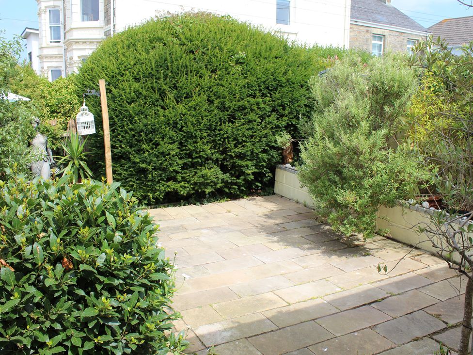 A garden with a paved area and bushes at Sea Whispers in Marazion