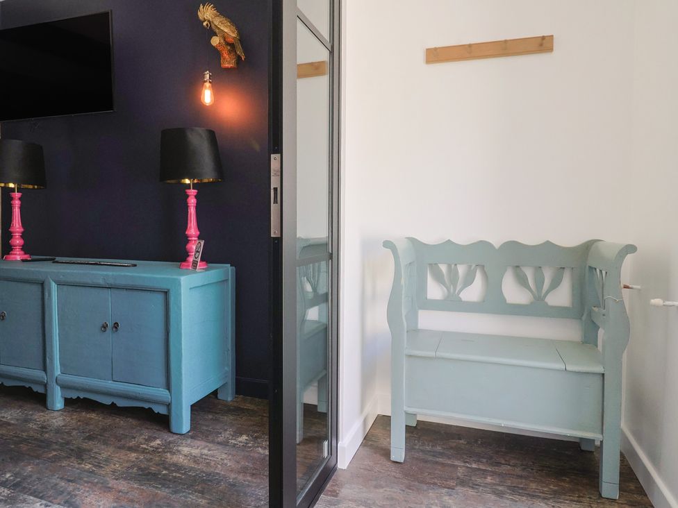 A hallway with a bench and cabinet at Avocet in Lyme Regis