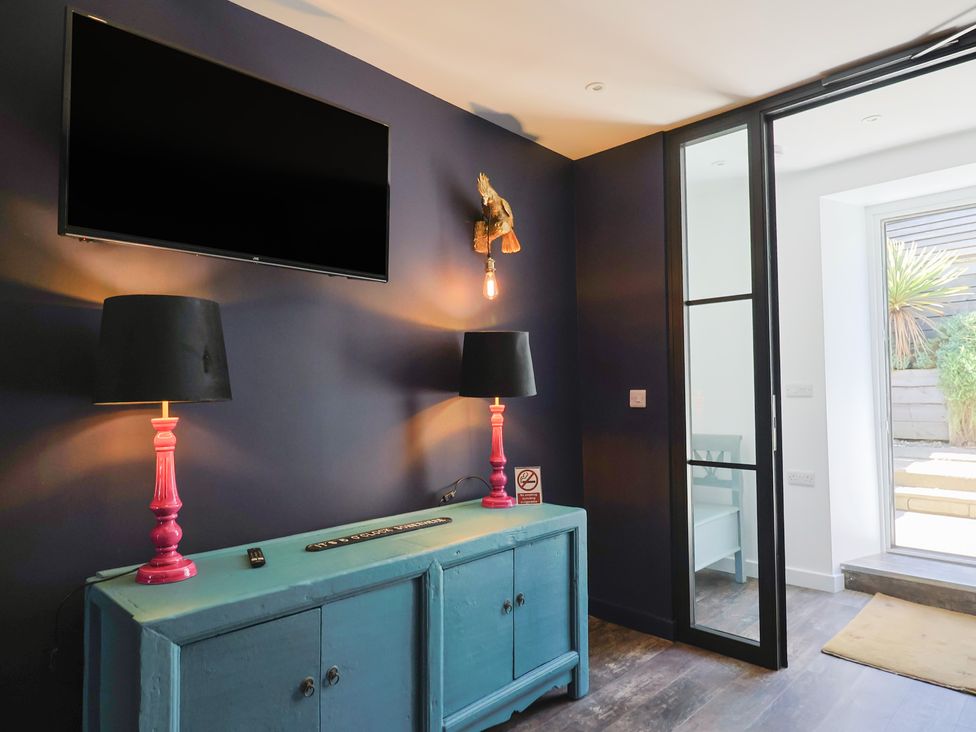 A living room with a television and lamps at Avocet in Lyme Regis