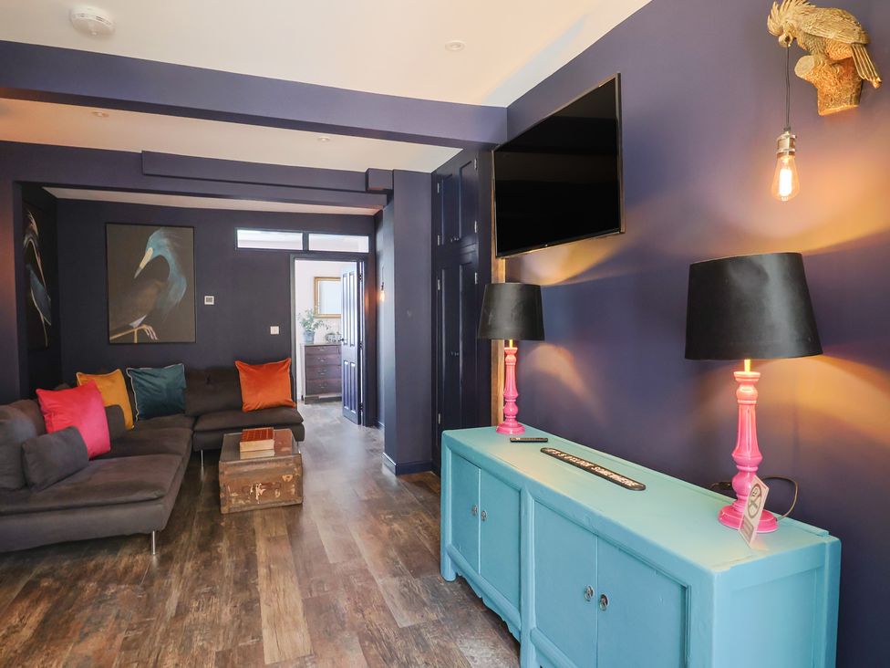 A living room with a sofa and lamps at Avocet in Lyme Regis