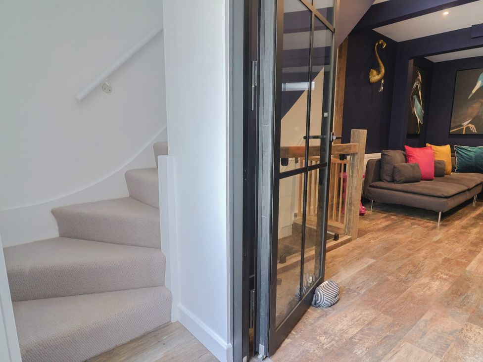 A lounge with a staircase and sofa at Avocet in Lyme Regis