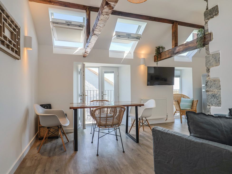 A living room with a table and chairs at Avocet in Lyme Regis
