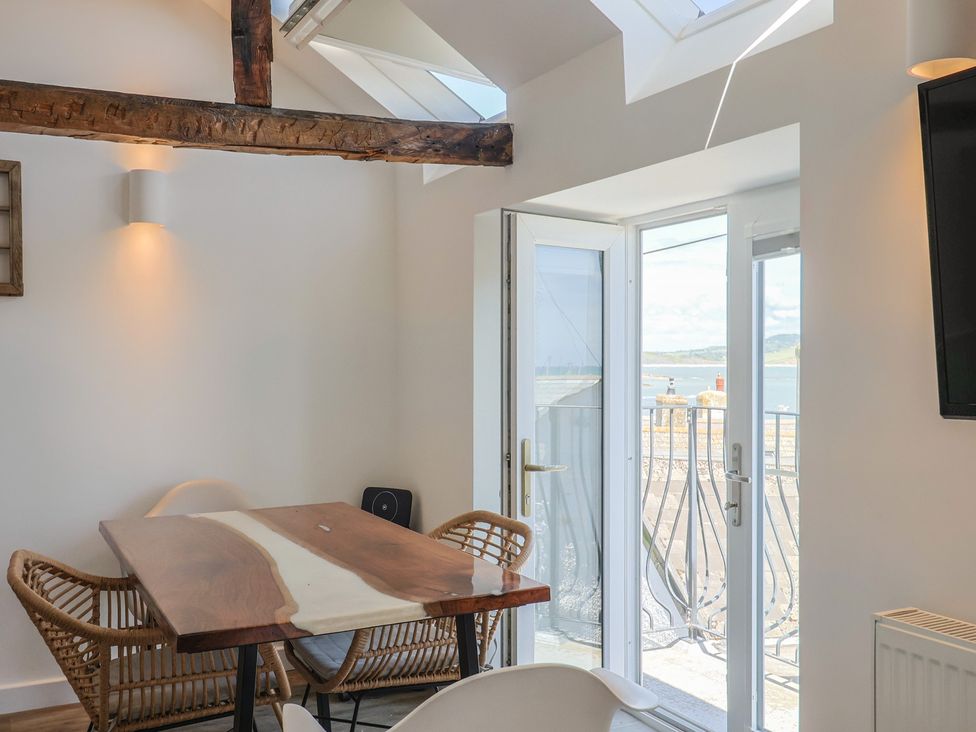A dining room with a wooden table and chairs at Avocet in Lyme Regis
