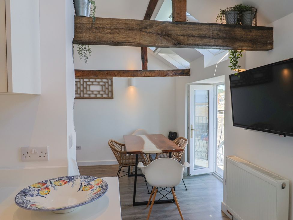 A dining room with a table and chairs at Avocet in Lyme Regis