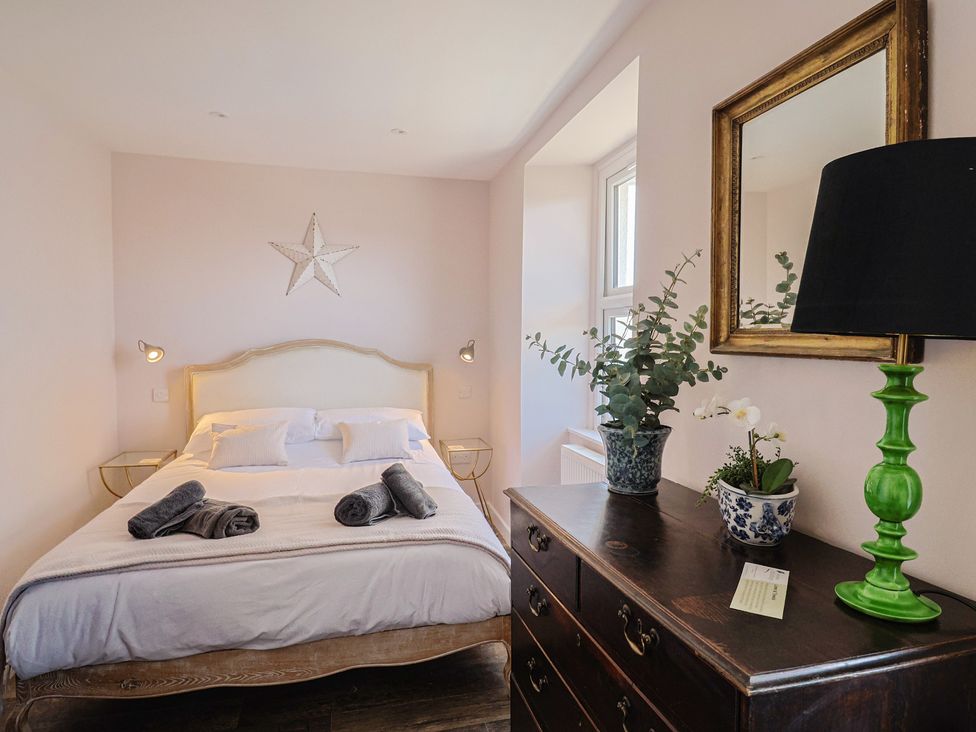 A bedroom with a bed and a dresser at Avocet in Lyme Regis