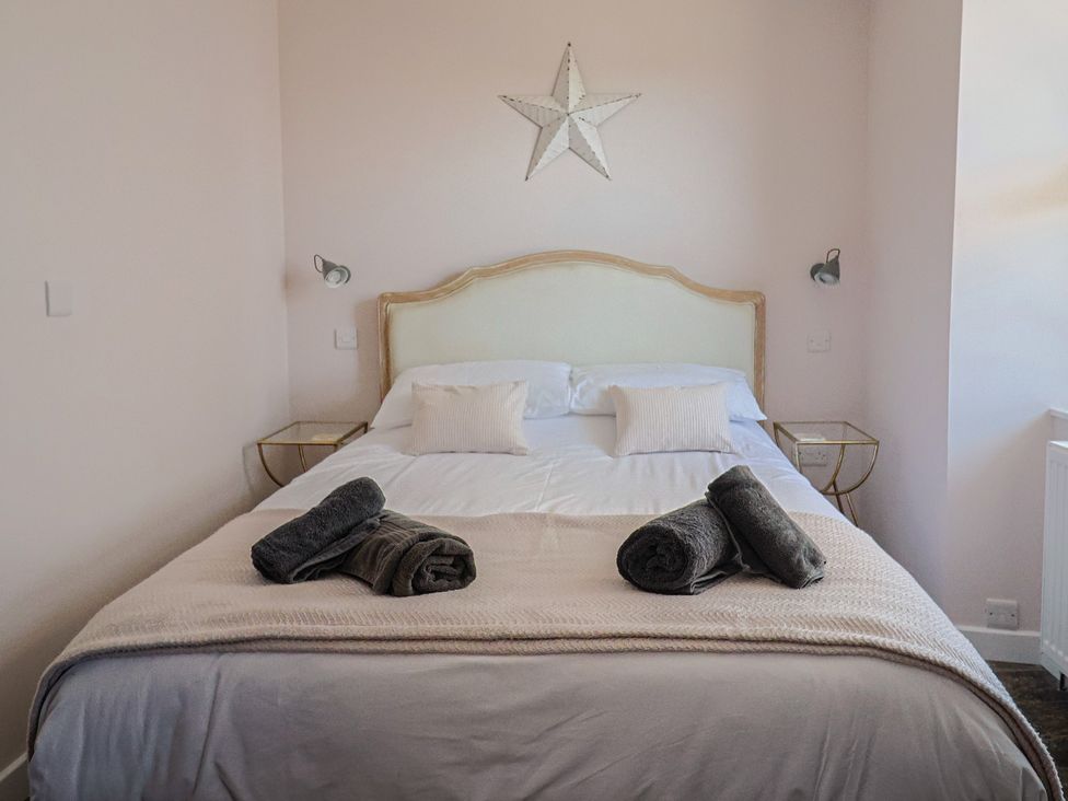 A bedroom with a bed and towels at Avocet in Lyme Regis