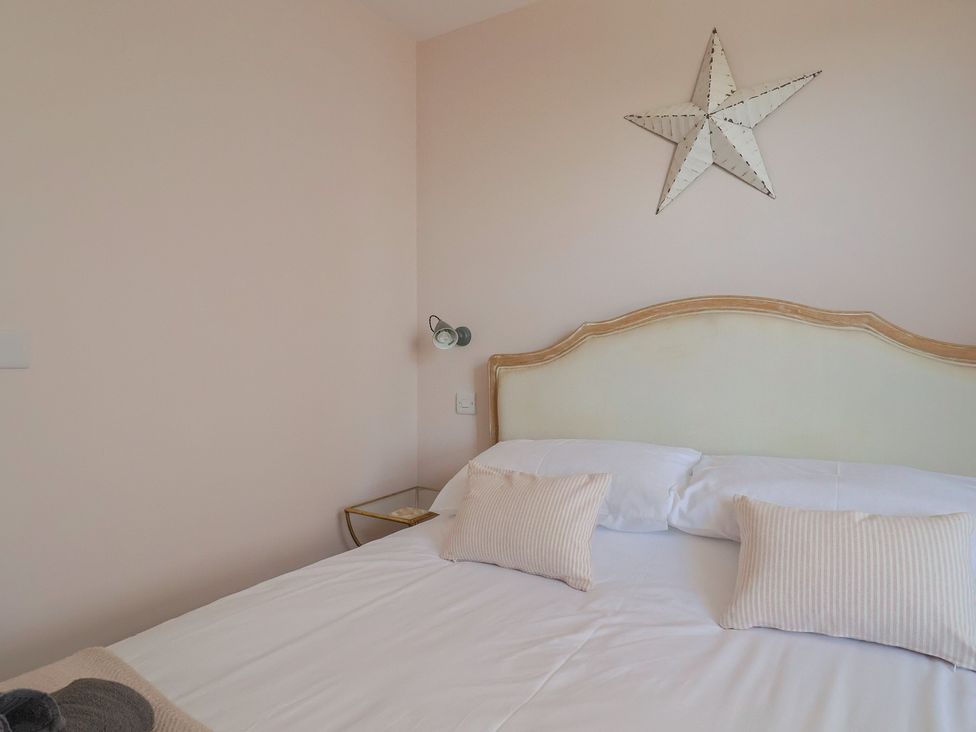 A bedroom with a bed and decorative items at Avocet in Lyme Regis