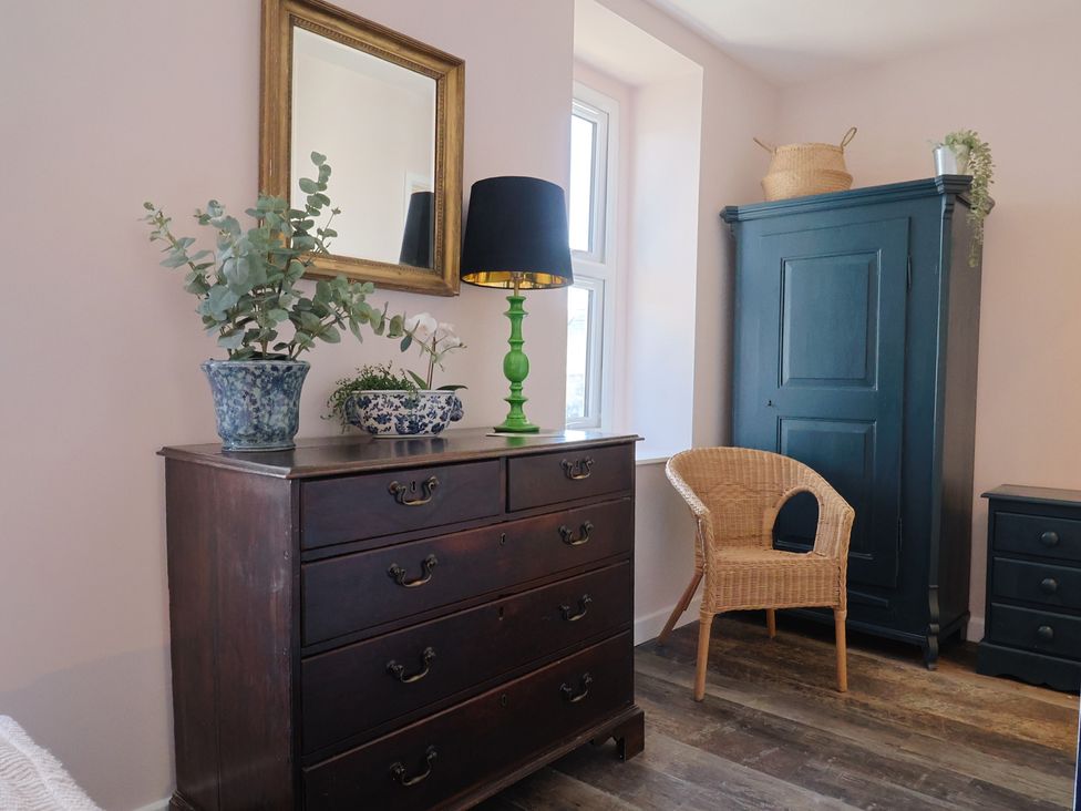 A bedroom with a chest of drawers and a wardrobe at Avocet in Lyme Regis