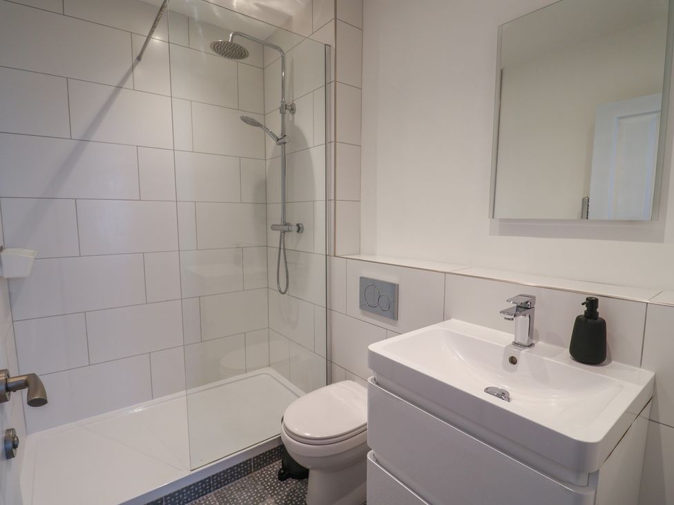 A bathroom with a shower, toilet, and sink at Avocet in Lyme Regis