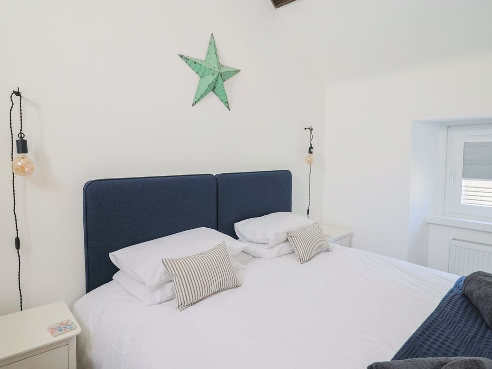 A bedroom with a bed and bedside table at Avocet in Lyme Regis