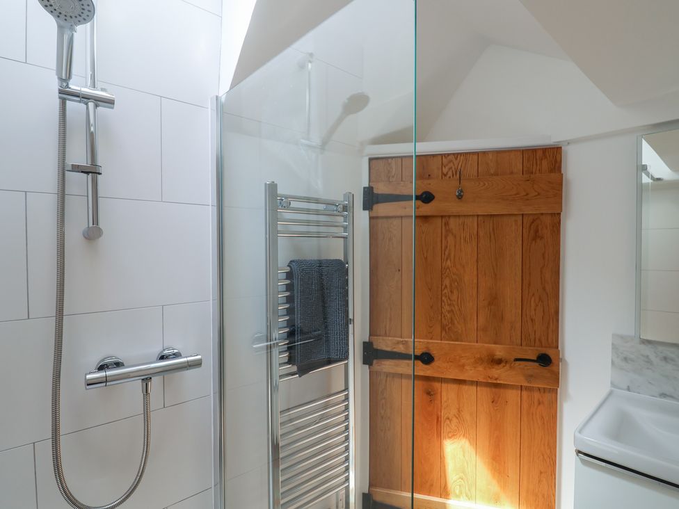 A bathroom with a shower and sliding door at Avocet in Lyme Regis