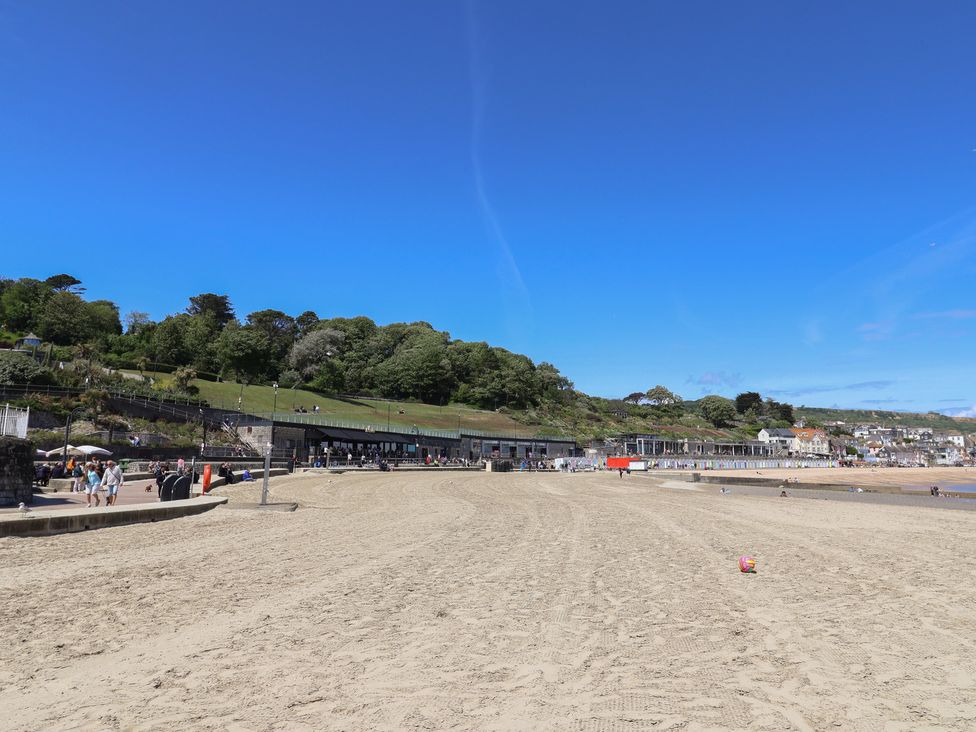 A beach with sand and people at Avocet in Lyme Regis