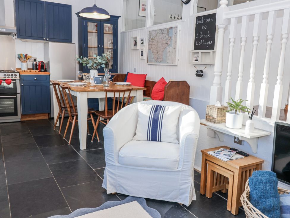 A living room with a dining table and sofa at 3 Brook Cottages Hope Cove