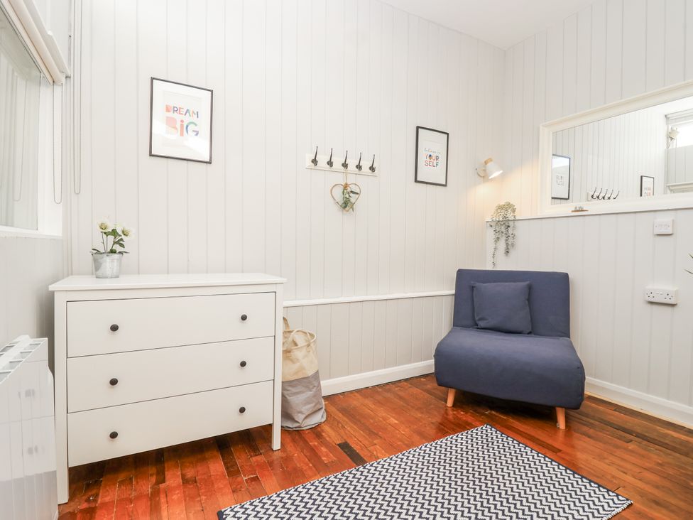 A living room with a dresser and armchair at 3 Brook Cottages Hope Cove
