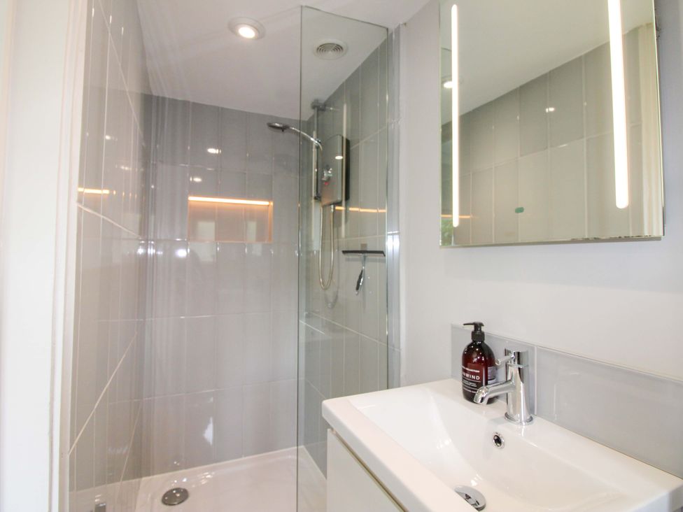 A bathroom with a shower and sink at 3 Brook Cottages Hope Cove