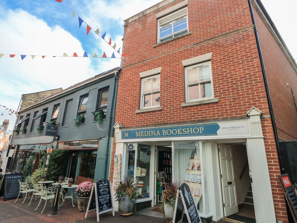 A bookshop with outdoor seating and signage at The Bookshop Apartment in Cowes