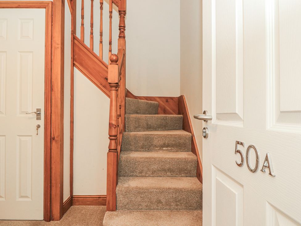 A staircase leading to upper levels and a door labeled 50A at The Bookshop Apartment in Cowes
