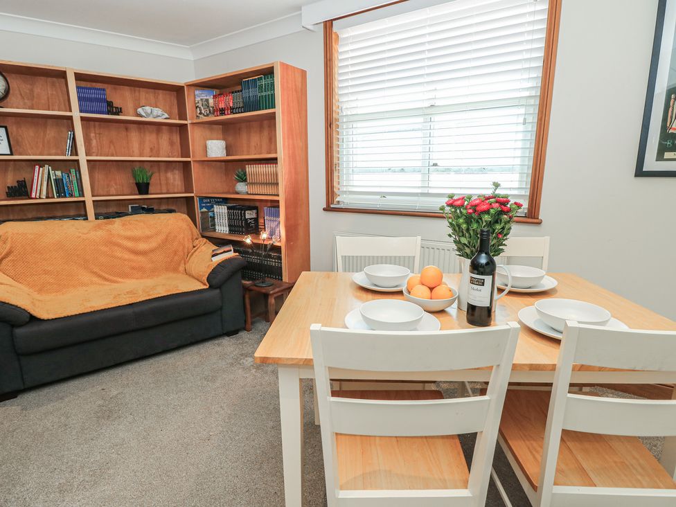 A dining room with a table and chairs at The Bookshop Apartment in Cowes