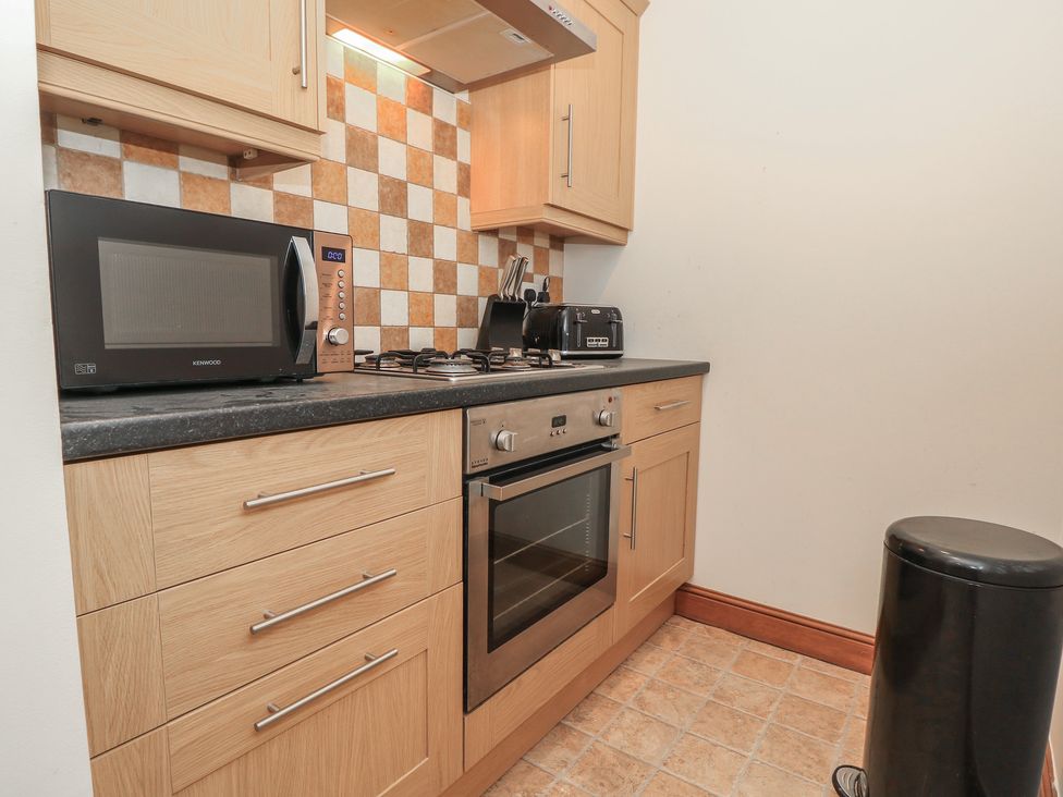 A kitchen with appliances and cabinets at The Bookshop Apartment in Cowes
