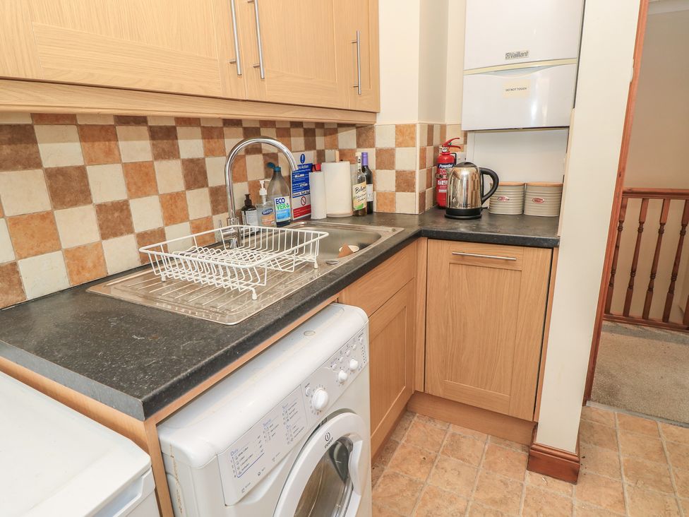 A kitchen with a sink and washing machine at The Bookshop Apartment in Cowes