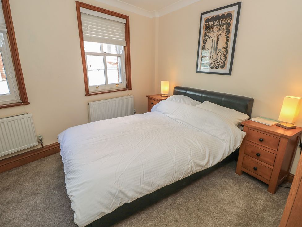 A bedroom with a bed and bedside tables at The Bookshop Apartment in Cowes