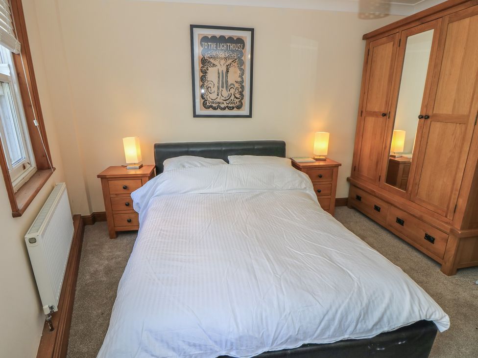A bedroom with a bed and wardrobe at The Bookshop Apartment in Cowes