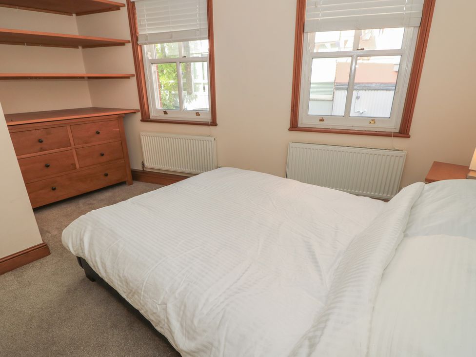 A bedroom with a bed and dresser at The Bookshop Apartment in Cowes