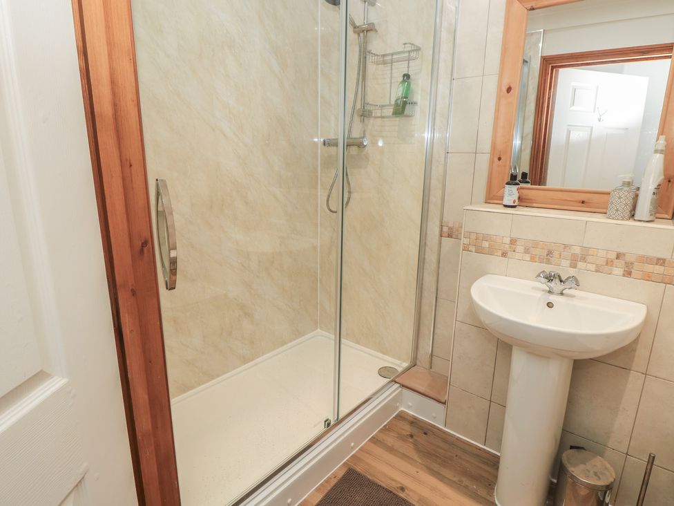 A bathroom with a shower and sink at The Bookshop Apartment in Cowes