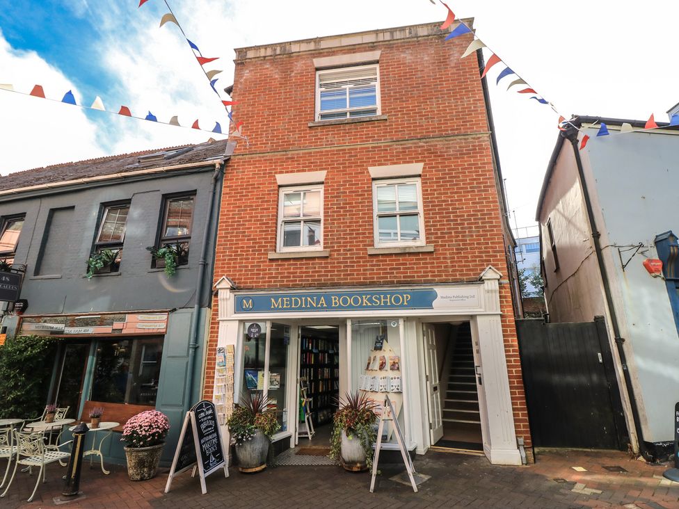 A storefront of a bookshop with windows and a sign at The Bookshop Apartment in Cowes
