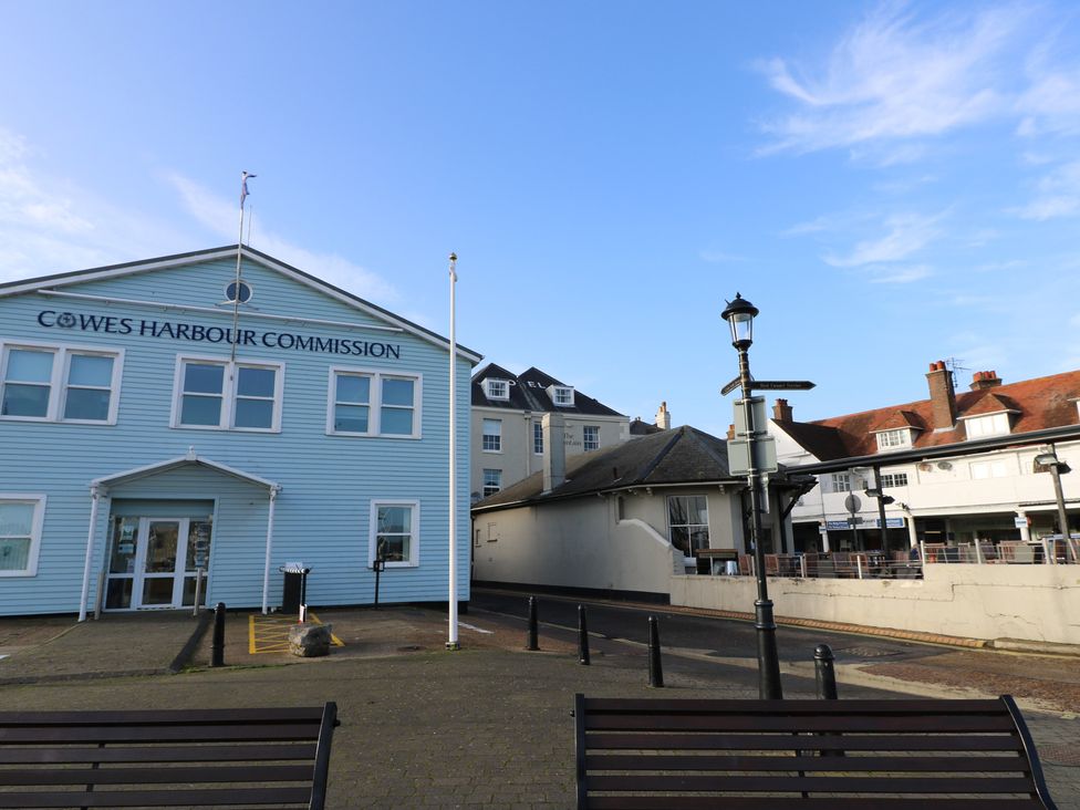 A building with Cowes Harbour Commission signage and street amenities at The Bookshop Apartment in Cowes