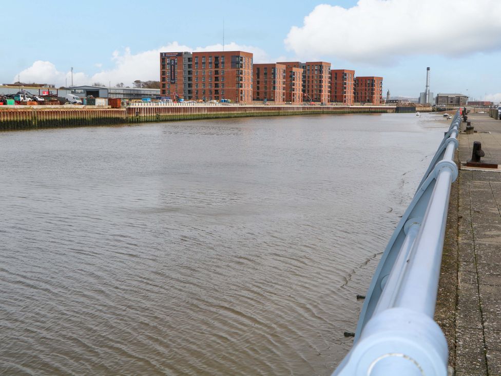 A river with buildings and a walkway at 67a Harbour Way Shoreham-by-Sea