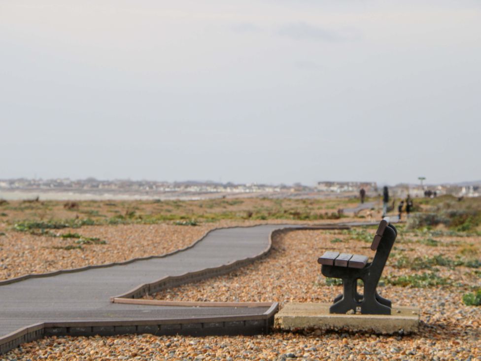 A pathway leading to the beach with a bench at 67a Harbour Way Shoreham-by-Sea