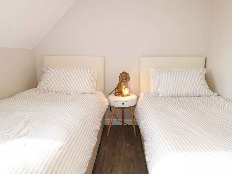 A bedroom with two beds and a lamp on a nightstand at 67a Harbour Way in Shoreham-by-Sea