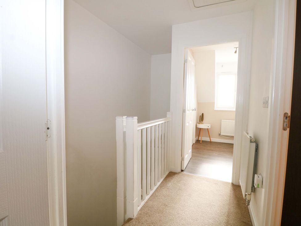 A hallway with a railing and doors at 67a Harbour Way Shoreham-by-Sea